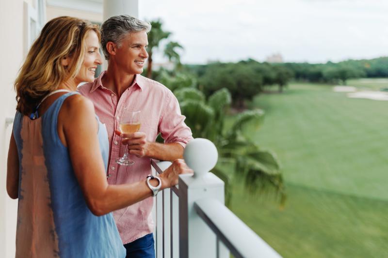 Couple on balcony overlooking golf course